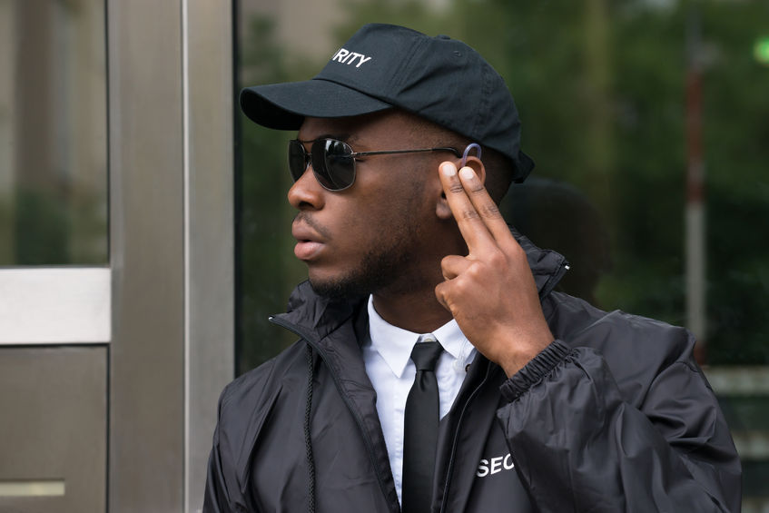 60869601 - young african male security guard listening to earpiece